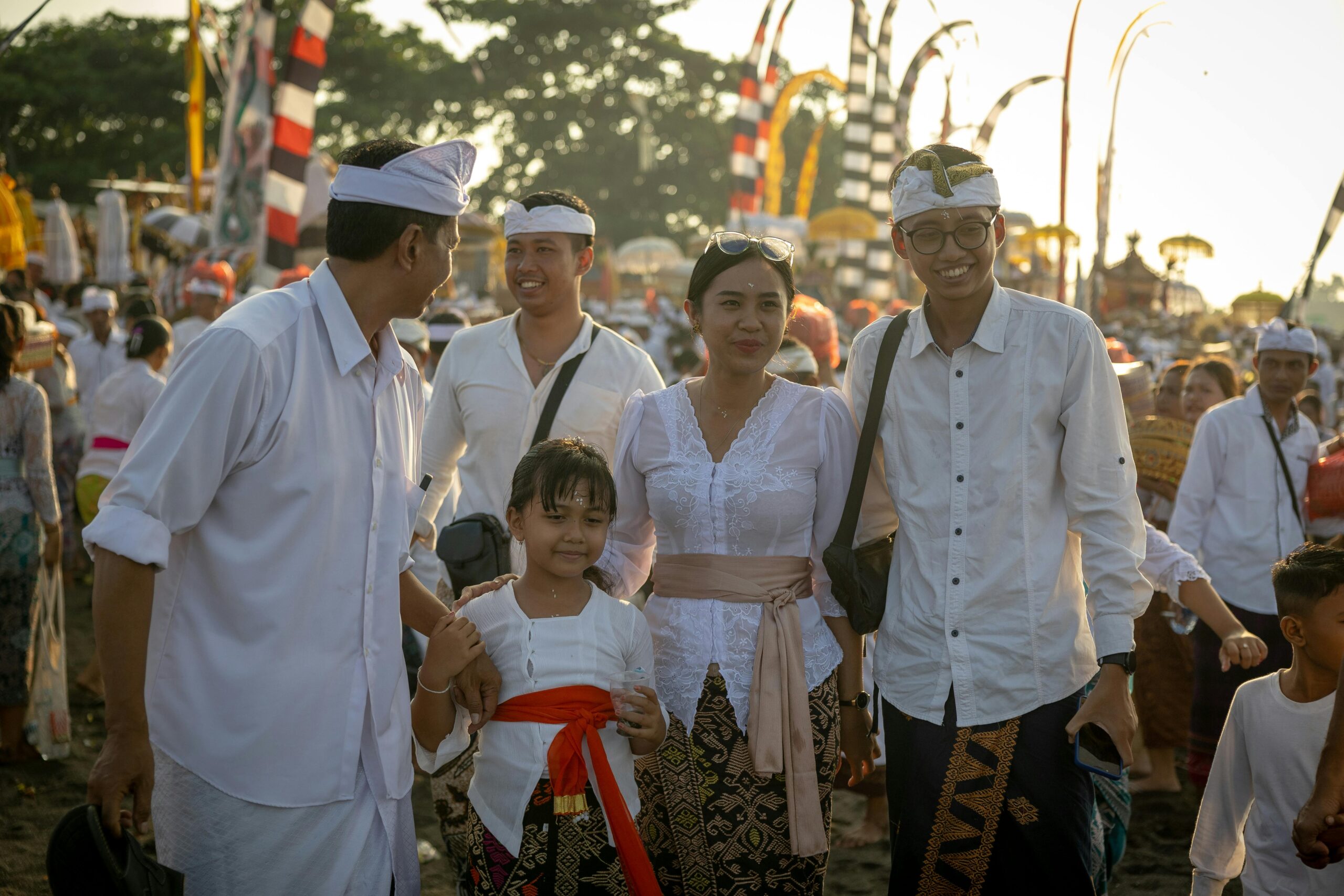 Die Familie genießt ein Kulturfestival auf Bali mit traditioneller Kleidung und farbenfrohen Dekorationen.