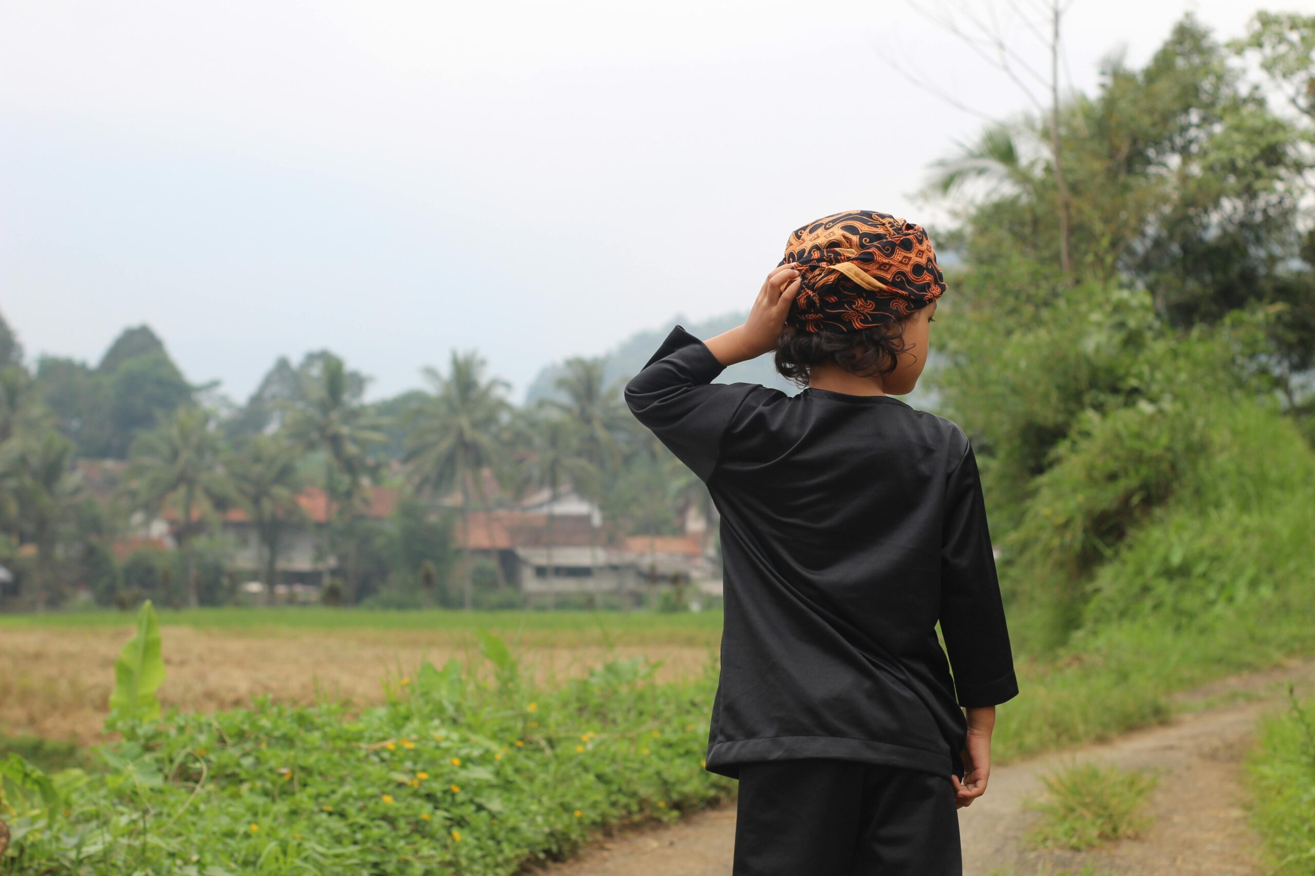 Ein Kind in traditioneller Kleidung steht im Freien in Sukabumi, West-Java, Indonesien.