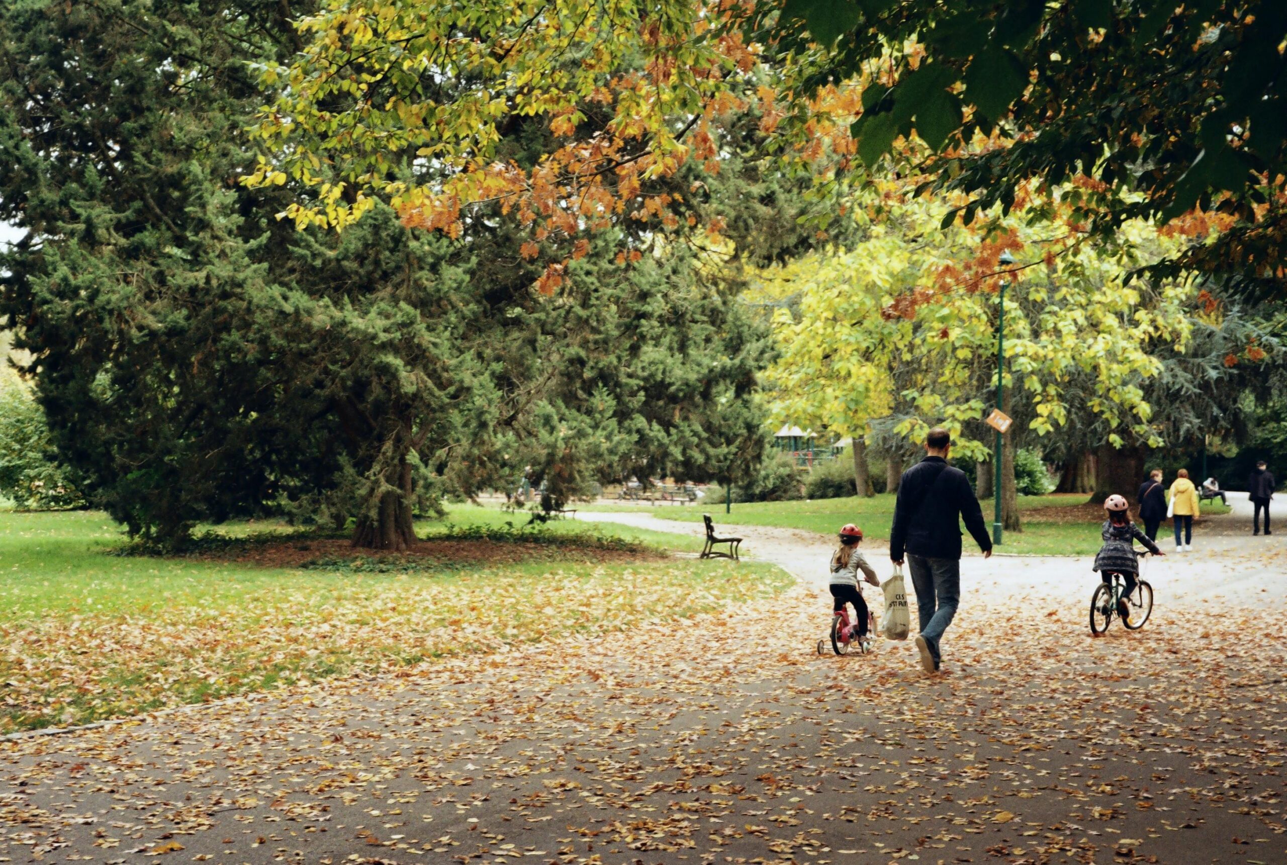 Eine Familie genießt im Herbst eine Radtour durch einen malerischen Park in Nancy.